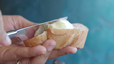 hand spreading butter on bread