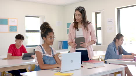 young biracial woman teaches in a classroom at high school