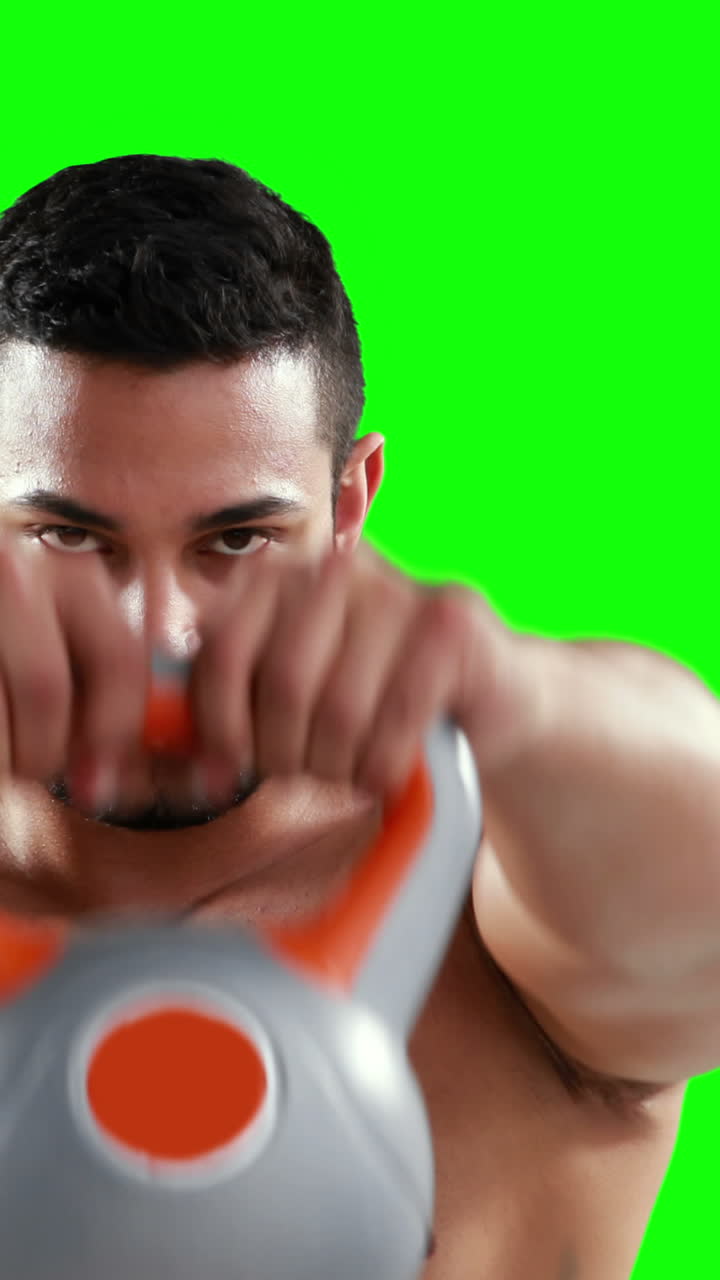 hombre musculoso serio levantando kettlebells