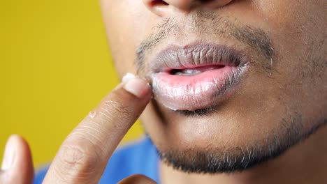 hombre aplicando bálsamo labial a los labios agrietados