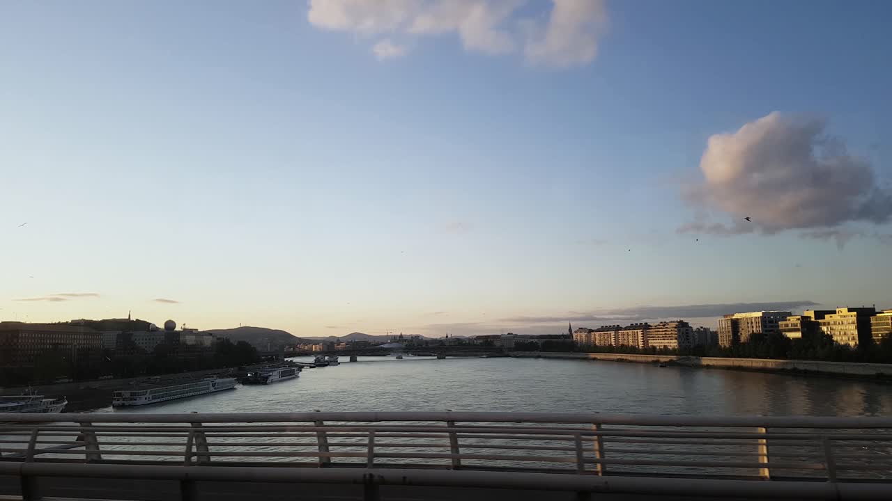 부다페스트 다뉴브 강은 건물이 있는 일몰과 파노라마가 있는 해충에서 부다까지 다리를 건너고 있습니다.