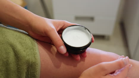 close-up view of woman applying cream on her knee, part of skincare routine, moisturizing, body care, rejuvenating, healthy skin, self-care, body-treatment, smooth skin, fresh skin