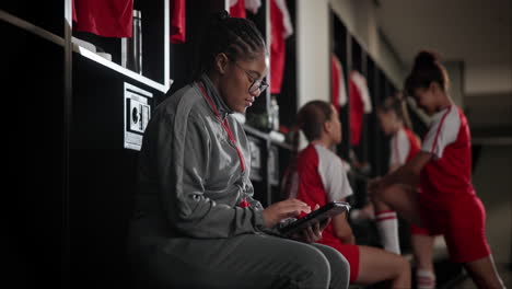 team coach with athletes in locker room