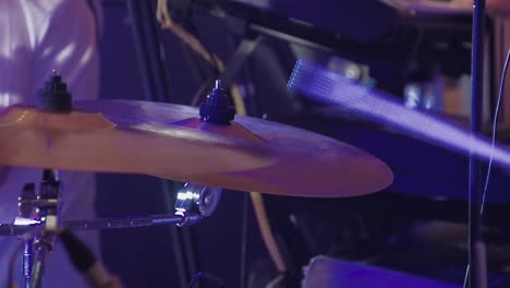 drummer plays percussion instruments at a concert as part of a musical group