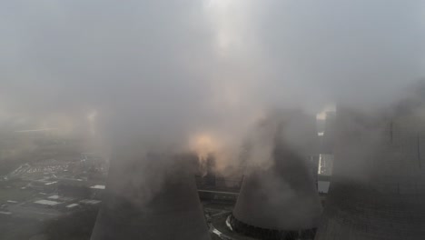 aerial view of uk power station cooling towers smoke steam emissions cloudscape atmosphere at sunrise