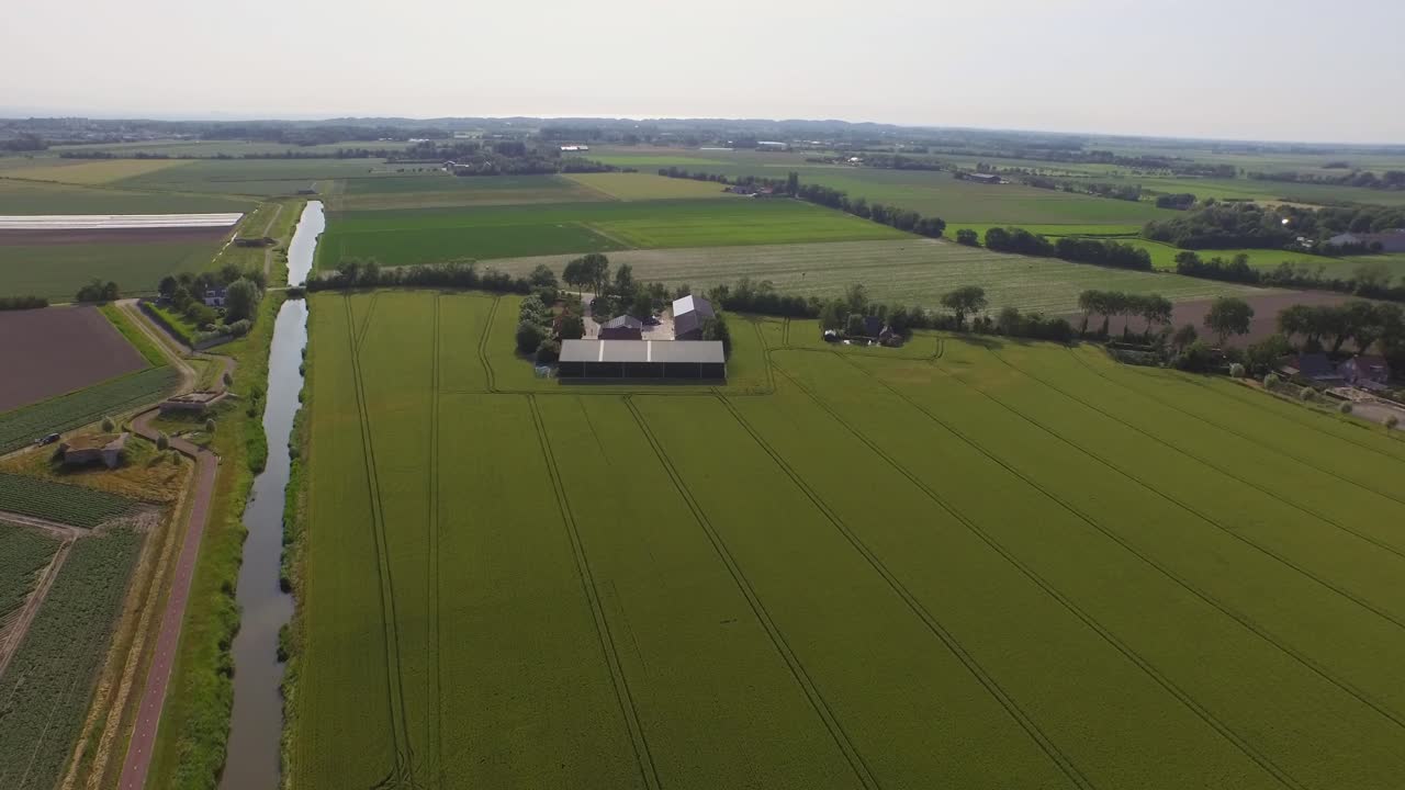 Aerial view of farmland with a canal and barn