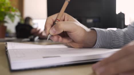 man handwriting in an office, making business plans