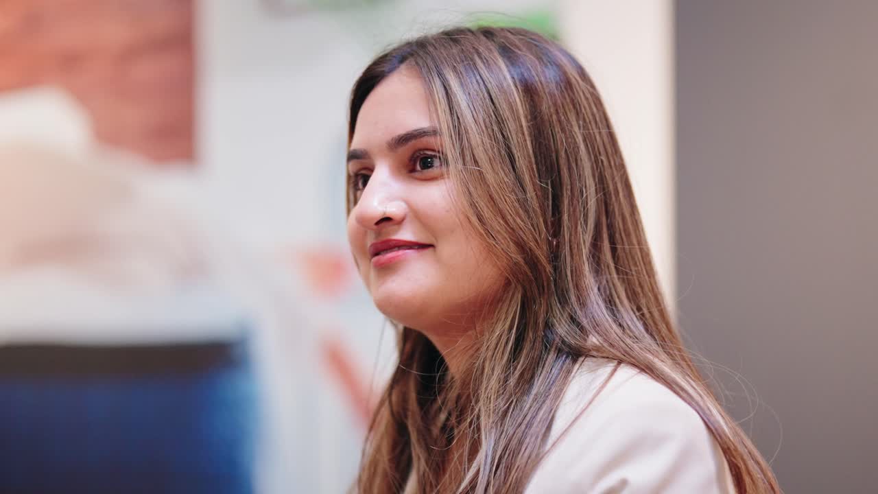 Seated associate nods happily in store aisle, captured in side profile