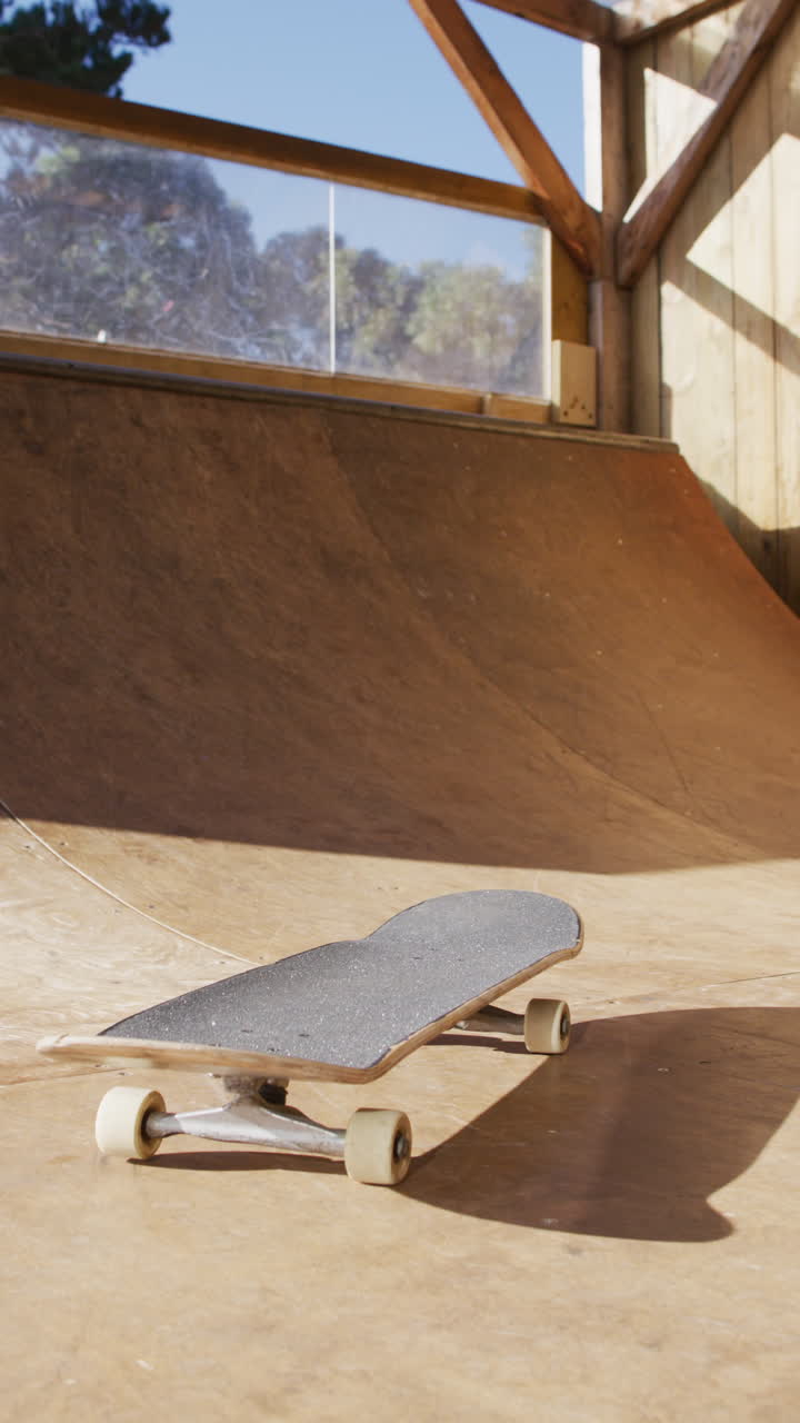 video vertical de una patineta tendida en un parque de patinaje