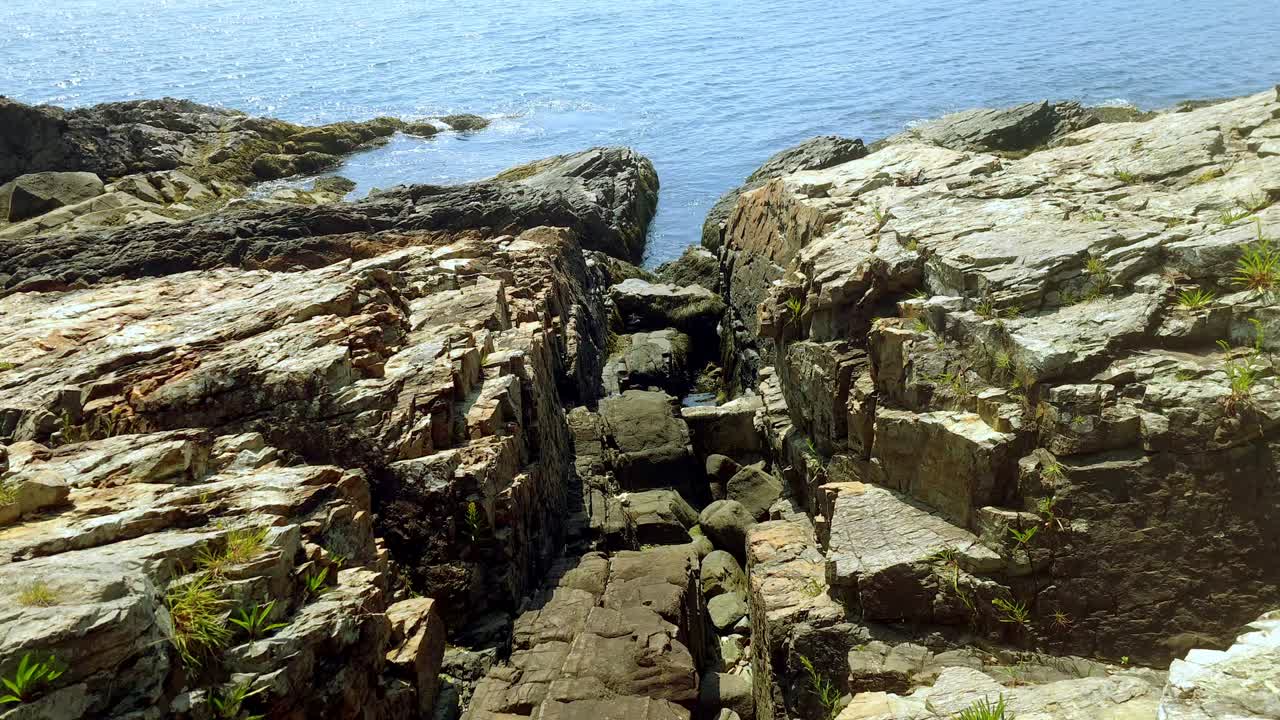 Granite rocks on ocean with a view of Ogunquit, Maine in the backgroud