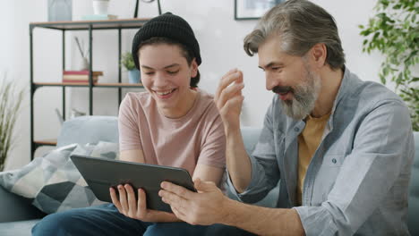 padre e hijo usando la tableta juntos