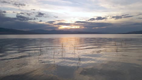 hermosa puesta de sol reflejada en el lago utah, drone volando bajo sobre el agua