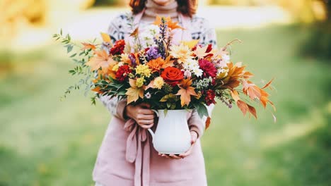 woman holding a vibrant autumn flower bouquet