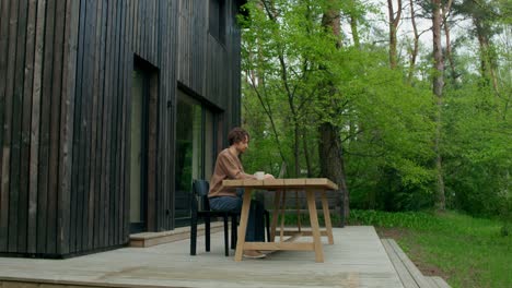 hombre trabajando desde casa en un patio con vistas al bosque