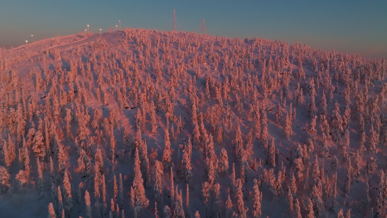 Aerial view rising toward the top of thr Sallatunturi fell, sunrise in Finland