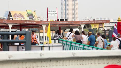 people boarding a ferry in bangkok, thailand