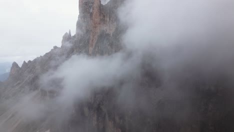 steep rock face with clouds in the mountains, dolomites, italy, europe, drone