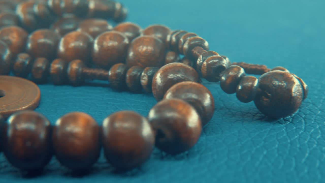 macro toma panorámica de un collar de cuentas redondas de madera con medallón de monedas