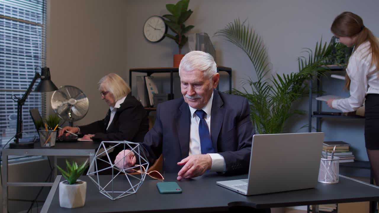 старик-бизнесмен танцует, празднует внезапную победу, носит солнцезащитные очки и ждет отпуска.