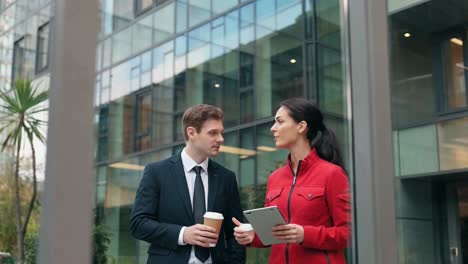 business professionals conversing outdoors by modern office building
