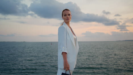 elegant woman enjoy seascape standing in front cloudy sky. lady looking sunset