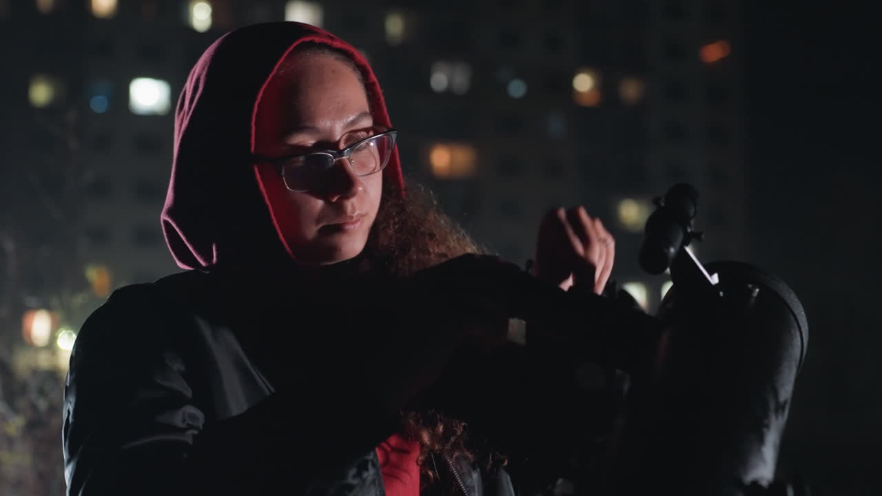 woman adjusts telescope on rooftop beneath city lights, hooded amateur astronomer finetuning eyepiece, quiet winter night, distant apartment windows, soft bokeh, methodical calibration, contemplative