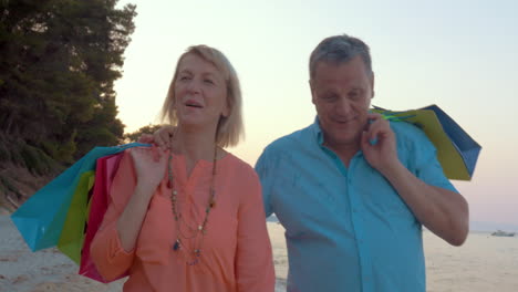 mature couple relaxing with seaside walk after shopping