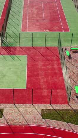 mini stadiums for doing sport outdoors. modern sport grounds in the city. red and green sport fields with artificial grass. view from above. vertical video