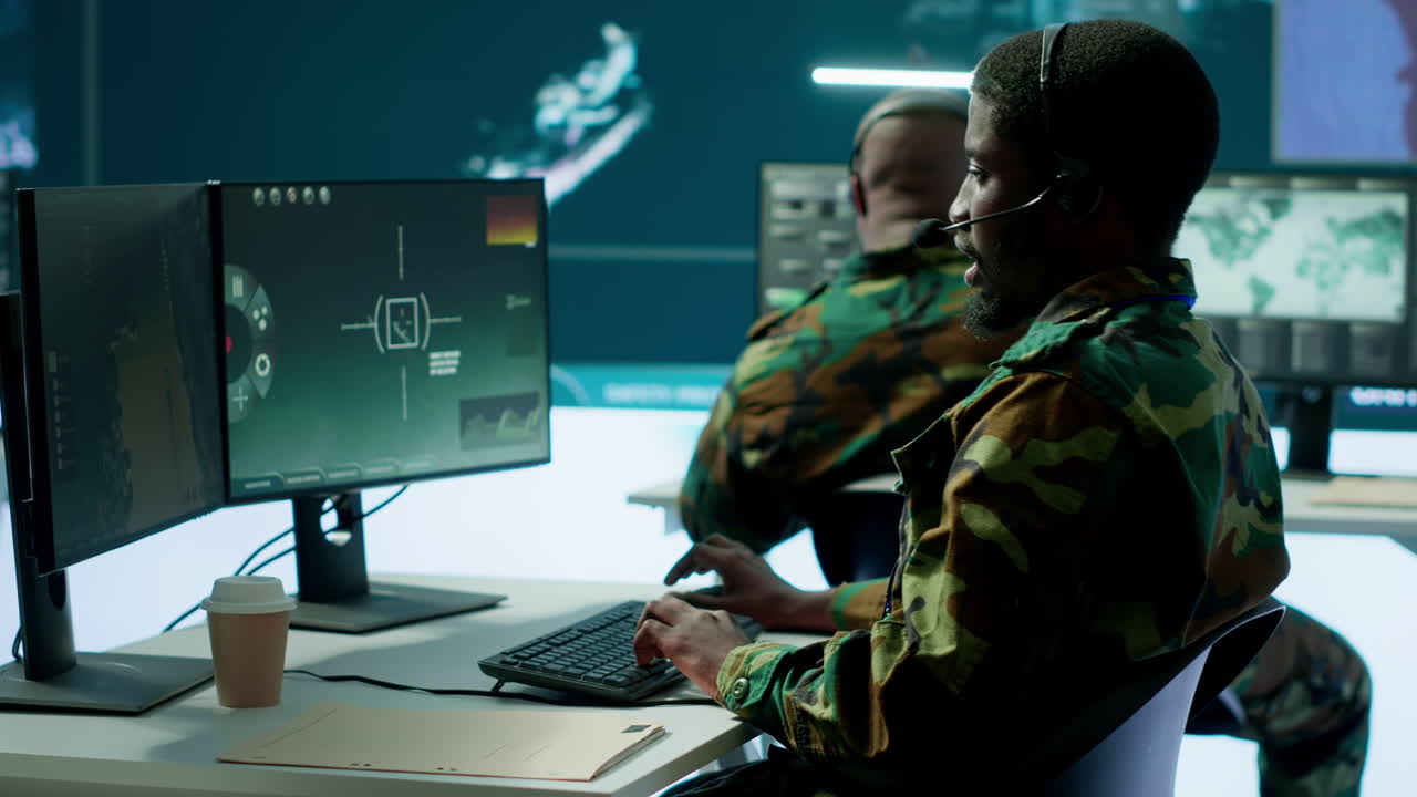 Army professional in uniform works in a mission control center