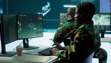 army professional in uniform works in a mission control center