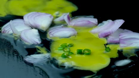 Mixing-green-chili-pepper-on-raw-egg-yolk-with-onion