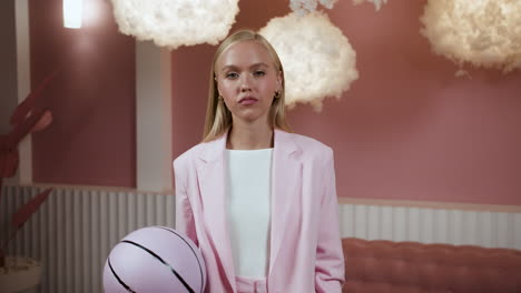 una chica rubia con una pelota en casa.