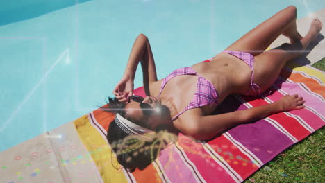 sunbathing on colorful towel, woman in sunglasses relaxing by swimming pool