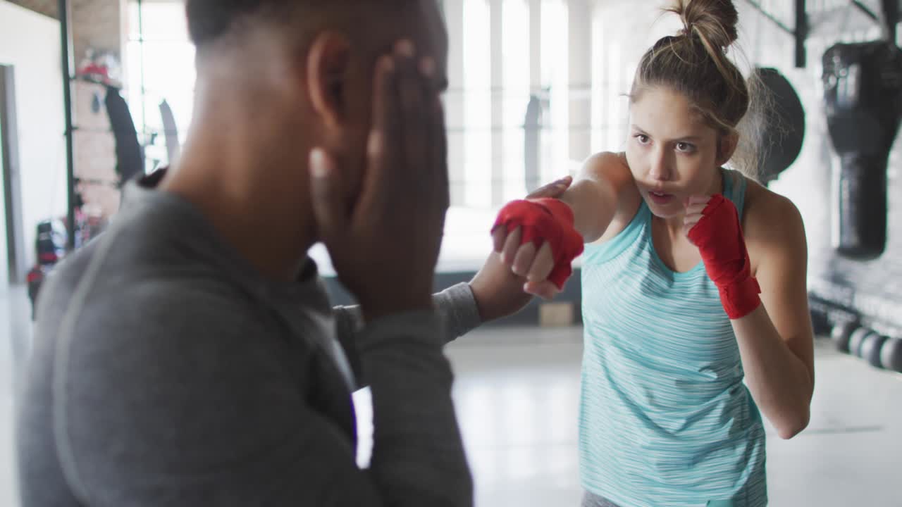 Allenatore di boxe che tiene i colpitori mentre l'allievo si muove e sferra jab, pannelli HUD che si accumulano guidando la mira