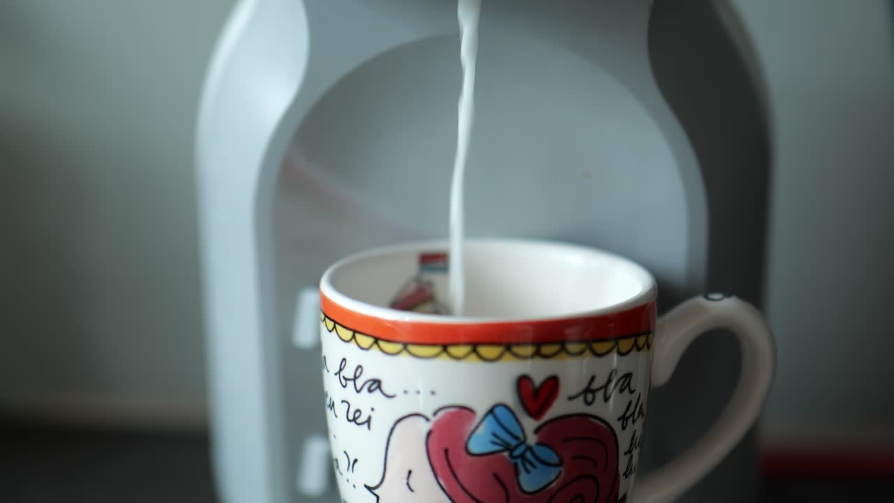 la leche se dispensa en una taza colorida de la máquina de café en el interior