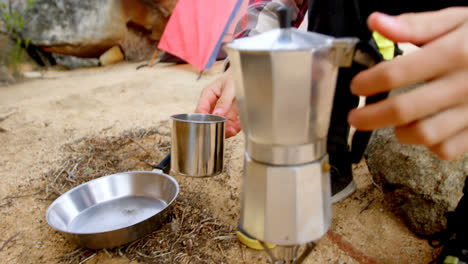 man pouring tea into mug from tea kettle 4k