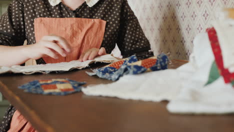 A-Woman-In-An-Antique-Dress-From-The-Time-Of-The-Development-Of-America-Is-Engaged-In-Needlework