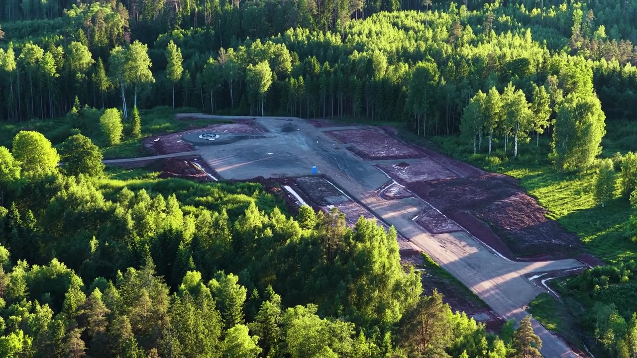 Staveniště základů větrné turbíny v bujném zeleném lese, letecký pohled