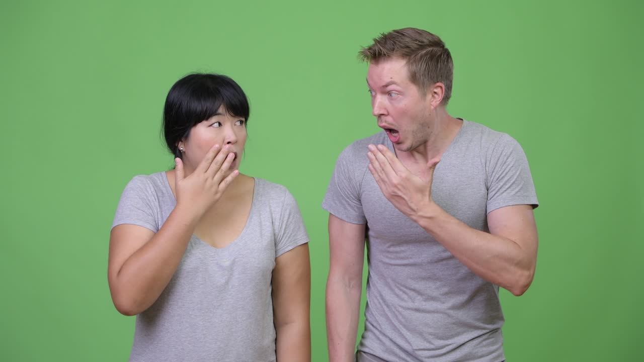 Young multi-ethnic couple looking shocked together