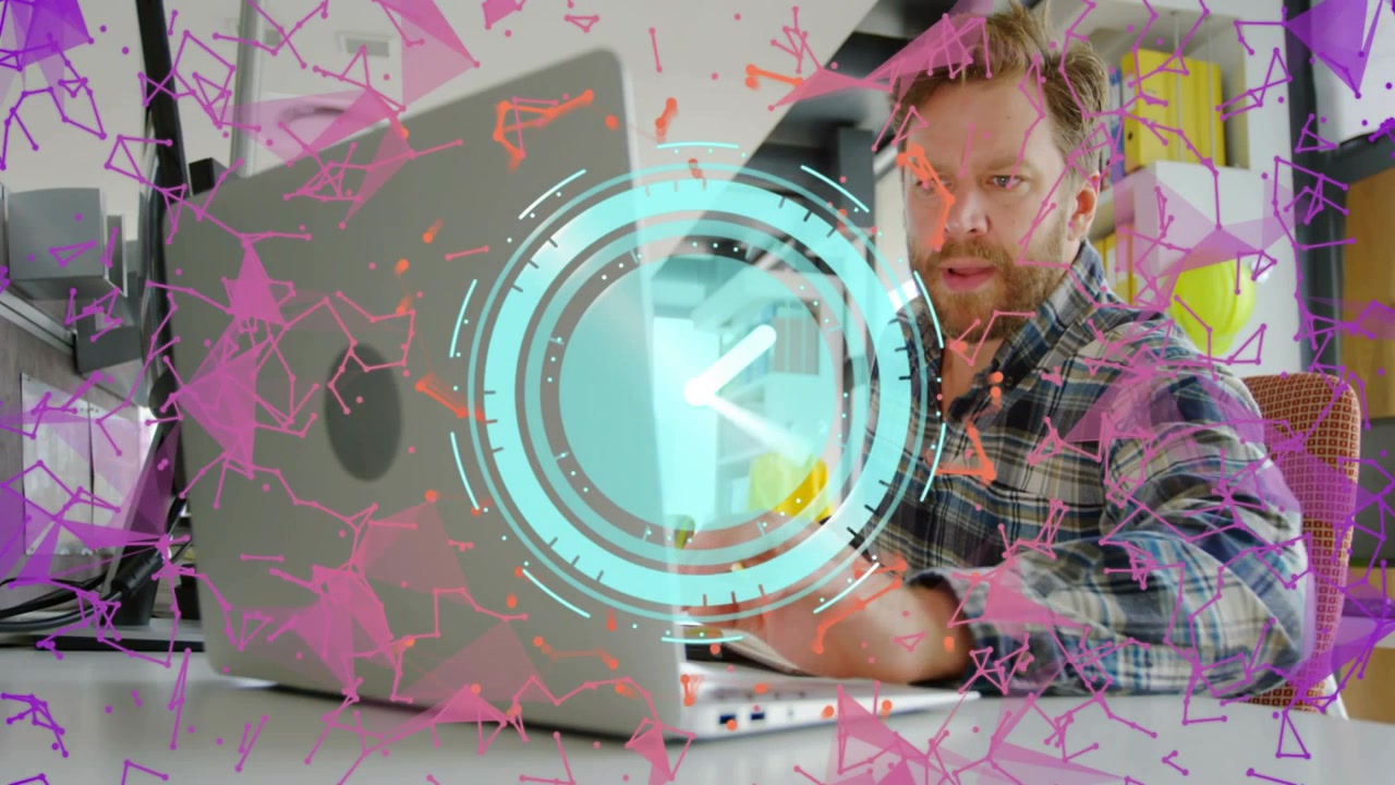 Uomo che usa un quaderno accanto al laptop, orologio che appare sopra il laptop e che provoca una digitazione focalizzata sul lavoro
