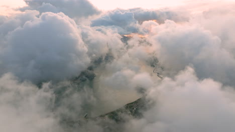 Aerial-revealing-shot-of-Victoria-Harbour-at-sunrise-with-dense-clouds-over-Hong-Kong-City