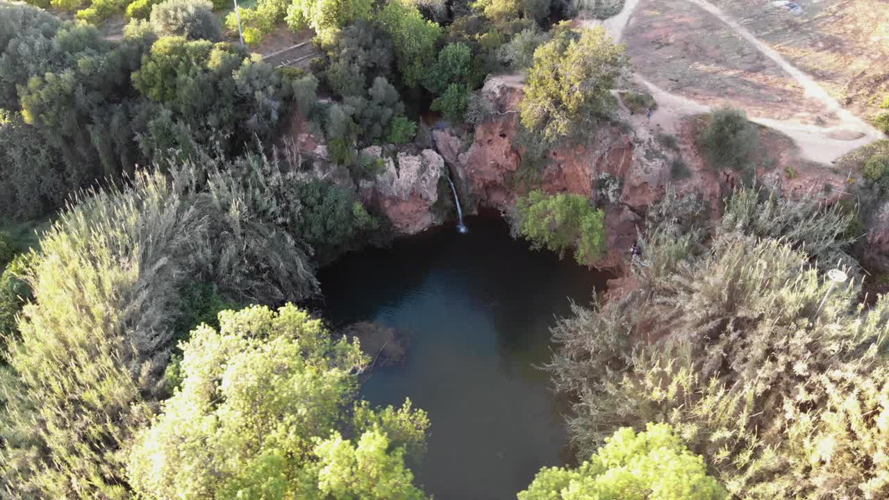 pego do inferno lago escondido y cascada en tavira, algarve, portugal - toma aérea de la órbita de la encuesta