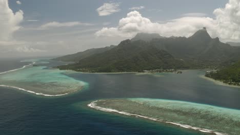 Aerial-dolly-left-shot-of-Mo'orea-island-surrounded-by-barrier-reef-in-French-Polynesia