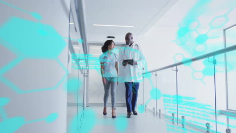 medical professionals walking corridor using tablet with molecular graphics floating