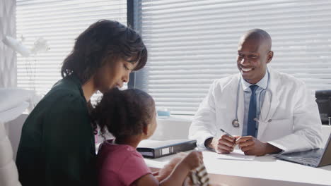 Mother-And-Daughter-In-Consultation-With-Doctor-In-Office