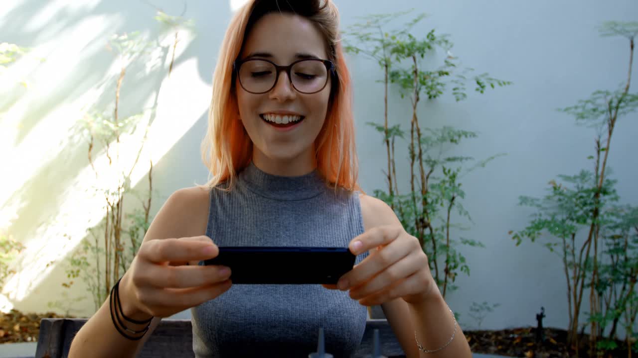 mujer joven fotografiando ensalada en la mesa en el restaurante 4k