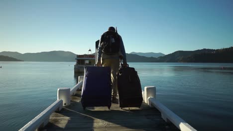 Männlicher-Passagier-Mit-Rucksack,-Gepäck-Und-Koffer,-Der-Morgens-Bei-Sonnenaufgang-Auf-Dem-Dock-Läuft-Und-An-Bord-Des-Bootes-Geht