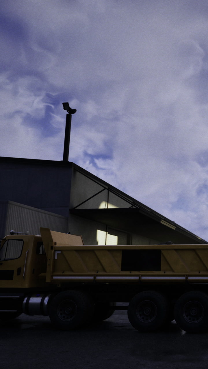 Dumper truck parked outside a building under a cloudy sky at dusk
