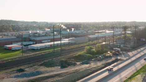 high aerial of usa factory beside railroad track and electricity generating transmission station