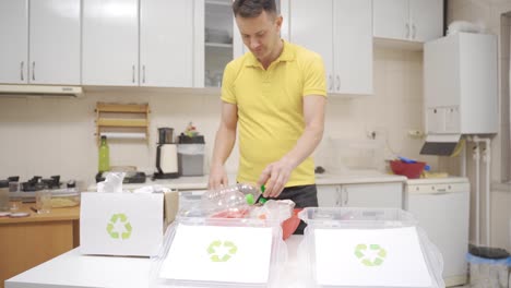hombre feliz que se preocupa por el reciclaje en casa. se está riendo.